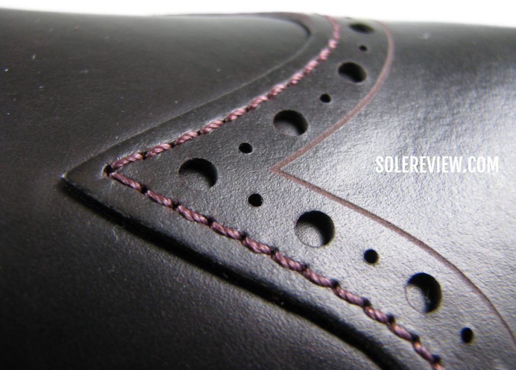 The stitching and laser details of the Cole Haan Grand Ambition Wingtip Oxford