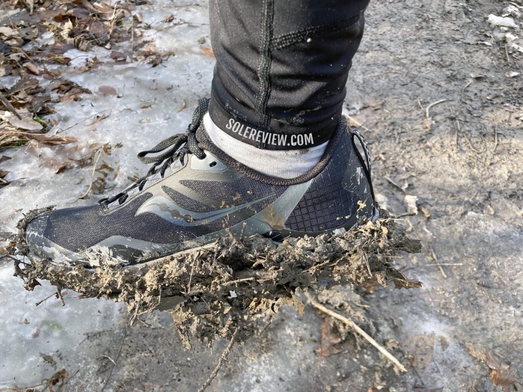 The Saucony Peregrine 12's outsole clogged with mud.