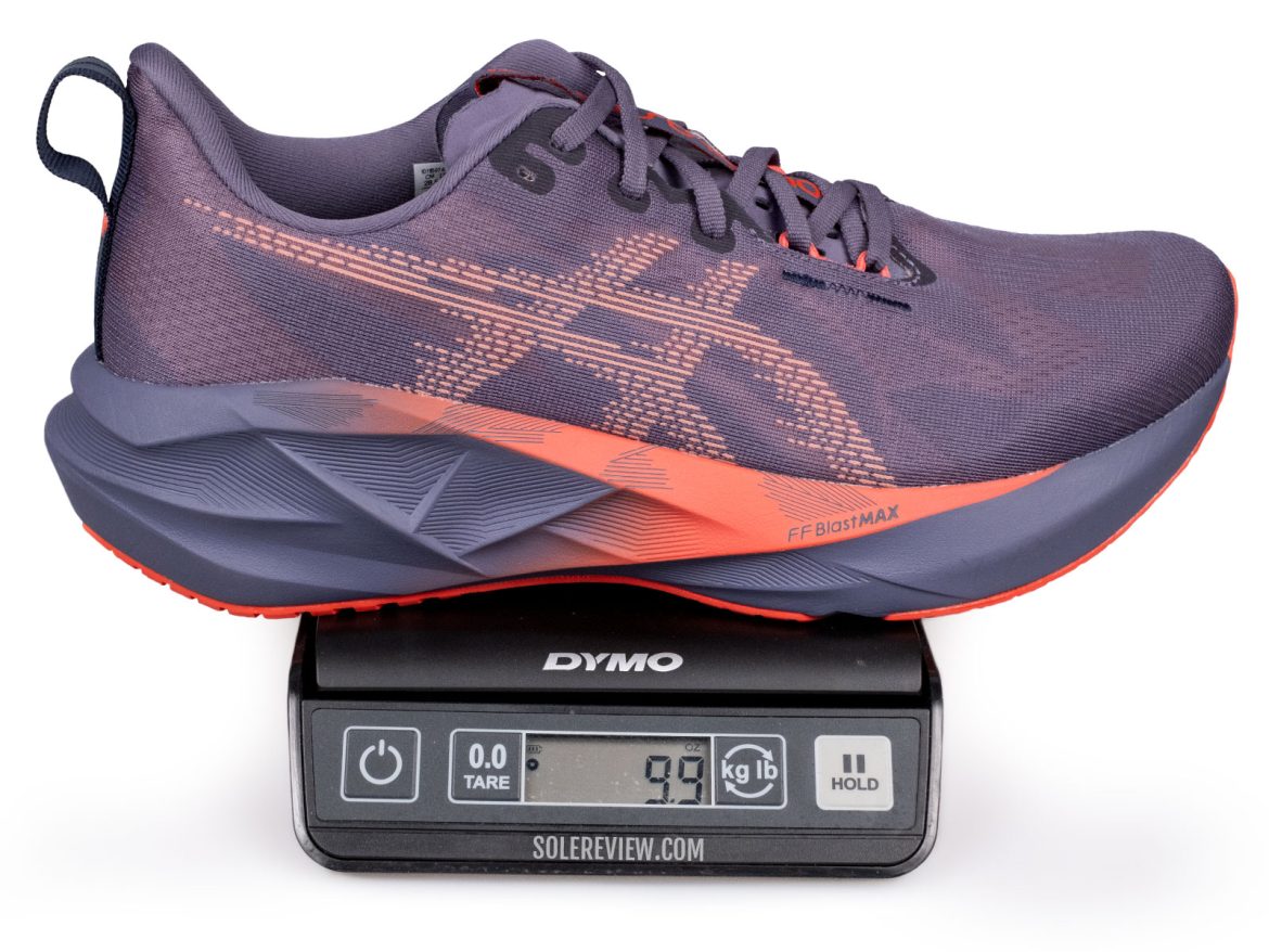 The Asics Novablast 5 on a weighing scale.